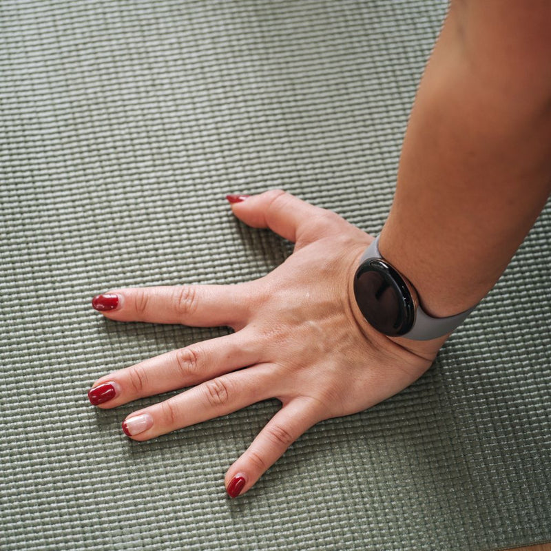 Close-up of a ladies hand on the floor with a smart watch on her wrist