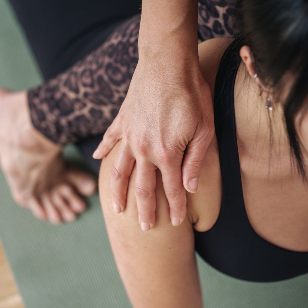 Close up of ladies hand on her shoulder in a yoga pose
